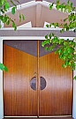 Copper Panels Applied to Front Doors made to mimic a reflection of the A-frame window above them, produced by Dwight H. Bennett.